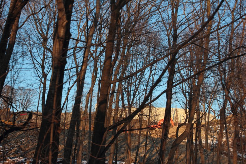 Blue sky and construction at the former Symmes site can easily be seen up through the wooded area that seems to be getting thinner and thiner.January 6, 2013.