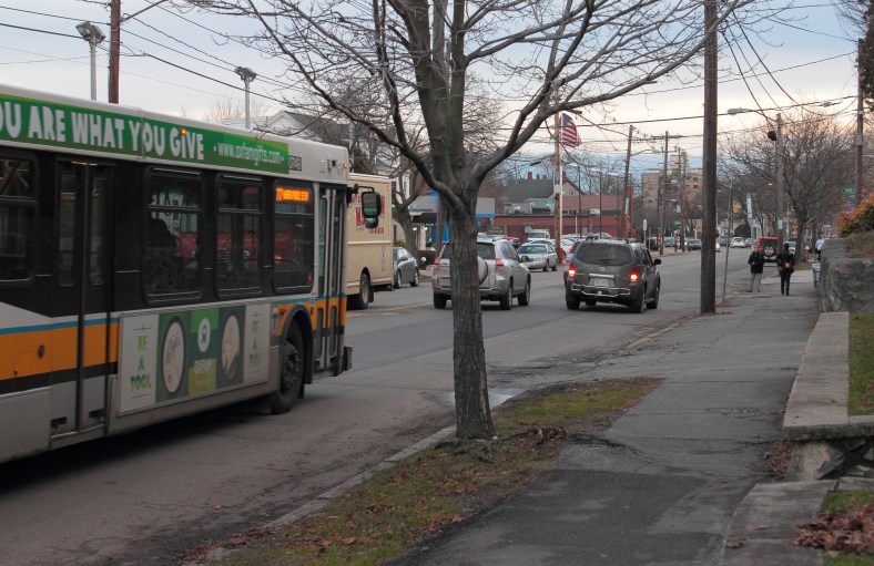 The 77 bus bears down on an SUV driving slowly past the bus stop due to a flat tire.January 14, 2013.