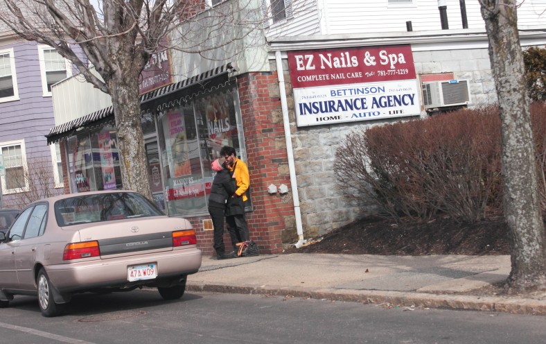 A couple cuddle up close while chatting outside on a chilly day.March 16, 2013.