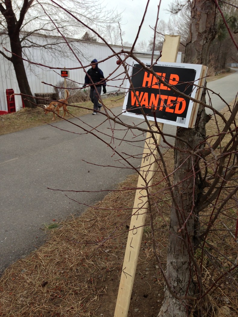 Signs posted along the bike path advertise jobs at a nearby landscaping company.March 18, 2013.