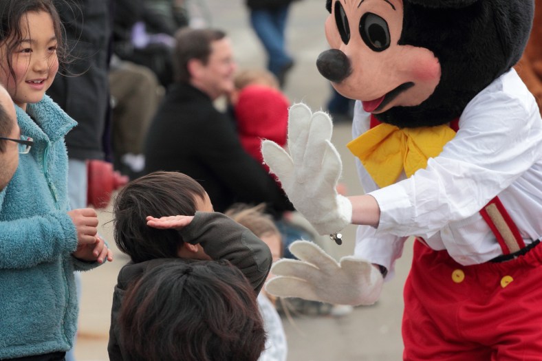 A young boy goes to high five some sort of cartoonish rodent during the Patriots' Day Parade. April 14, 2013.