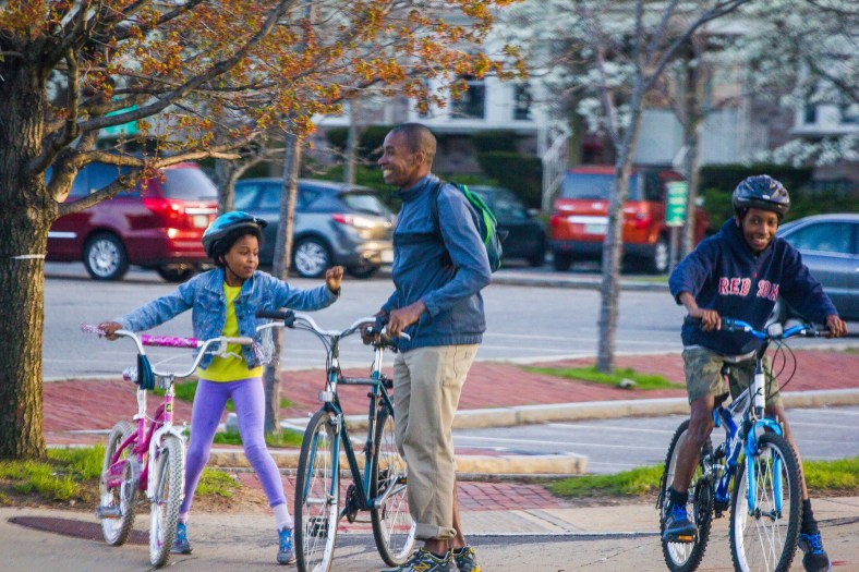 Waiting for the Light A father and his kids laugh as they wait to safely walk their bikes across the intersection of U.S. route 3 and MA route 60. April 28, 2013.