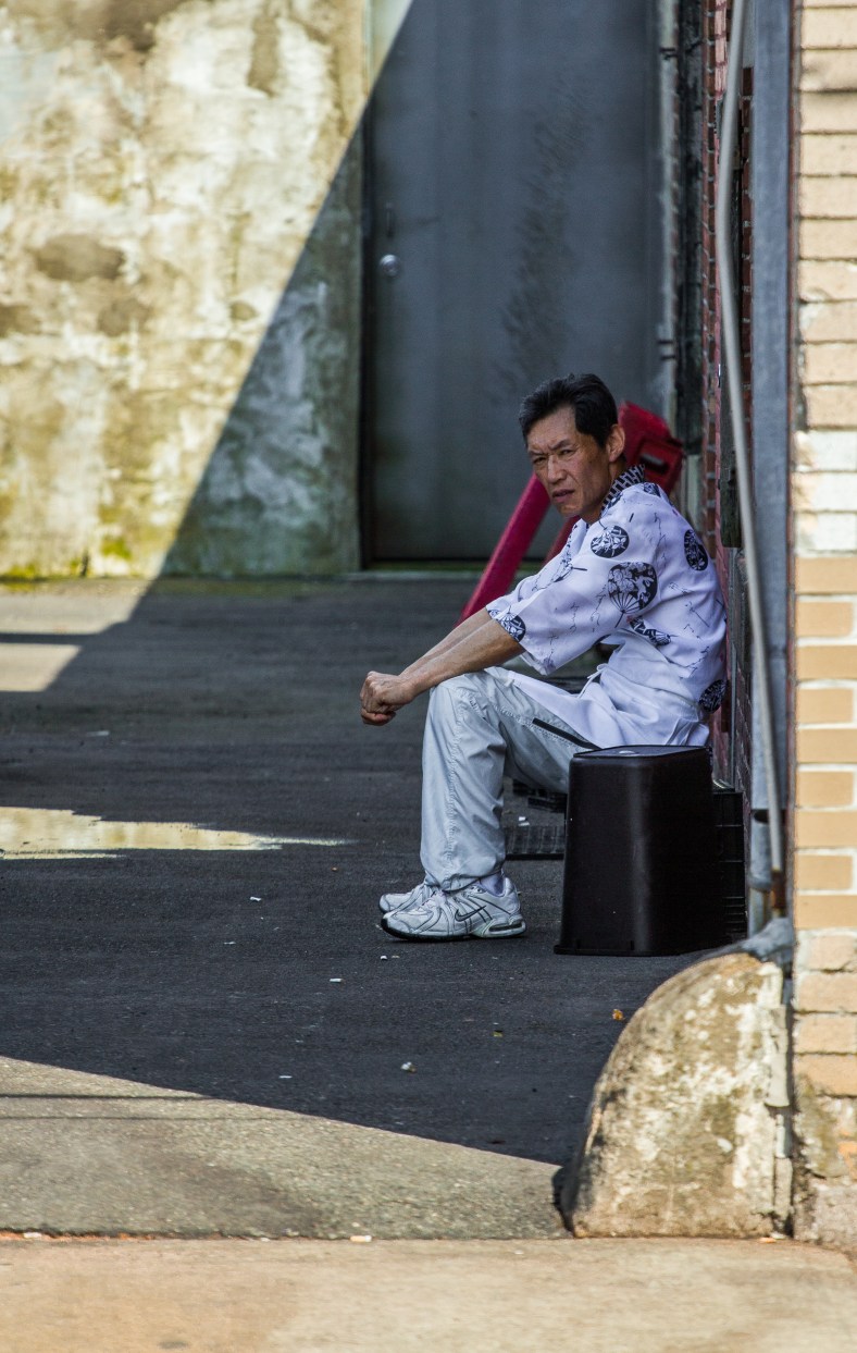 A sushi chef sits in the shade behind Mr. Sushi on Massachusetts Avenue during his break in the 95˚ heat. July 5, 2013.