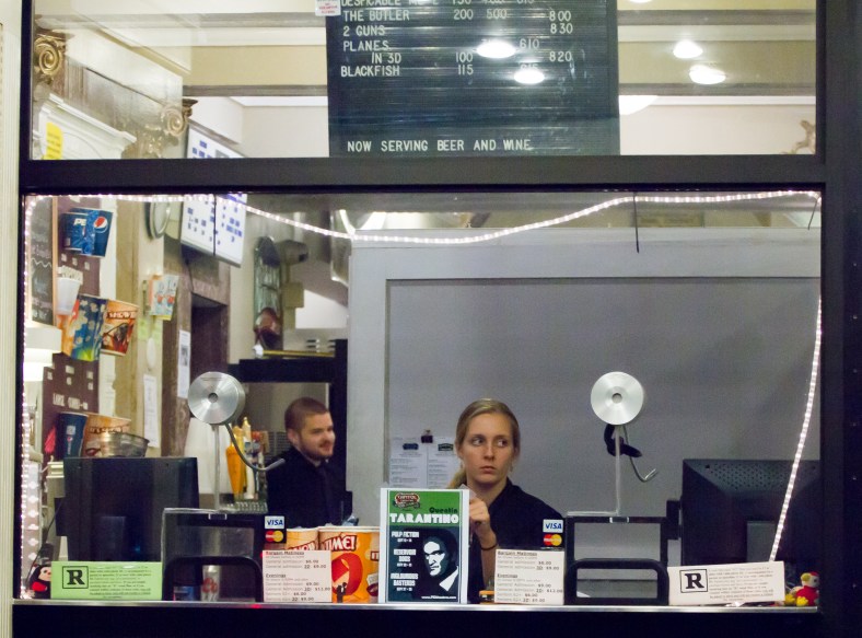 An employee looks for potential moviegoers as she sits in the Capitol Theatre box office. August 20, 2013.