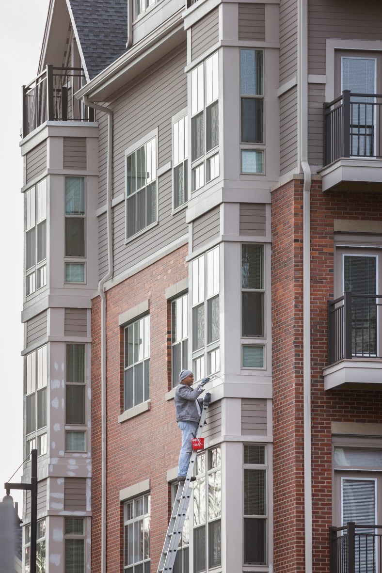 A painter puts the finishing touches on an apartment unit at Arlington 360. November 15, 2013.