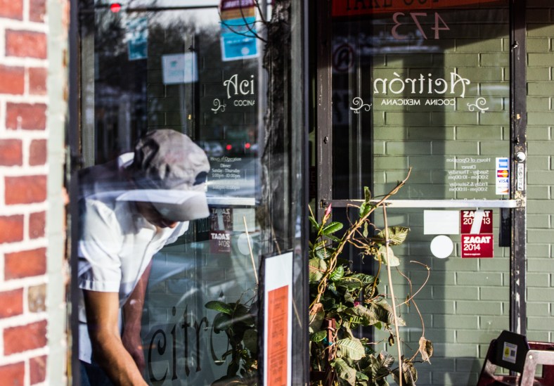 A man wipes down chairs before opening for dinner service at Acitron on Massachusetts Avenue. November 15, 2013.