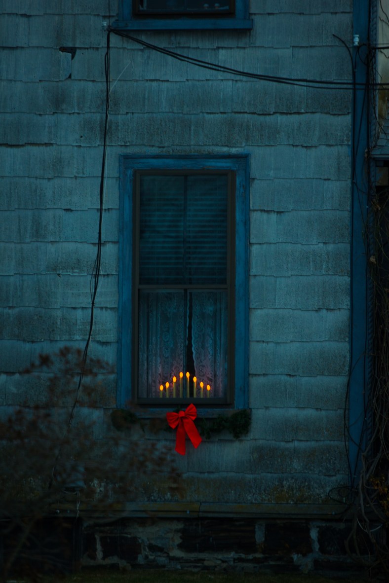 Electric candles and holiday decor brighten up a Warren Street home. December 24, 2013.