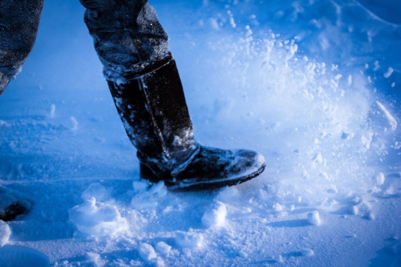 A woman kicks up snow as she walks across the Stratton School blacktop. January 3, 2013.