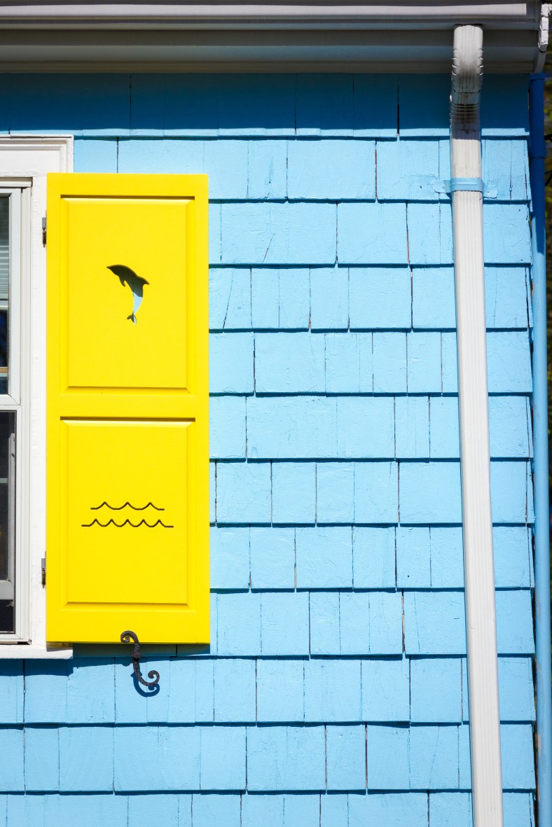 Cutouts of dolphins and waves on the colorful shutters of a Ridge Street home. May 12, 2014.