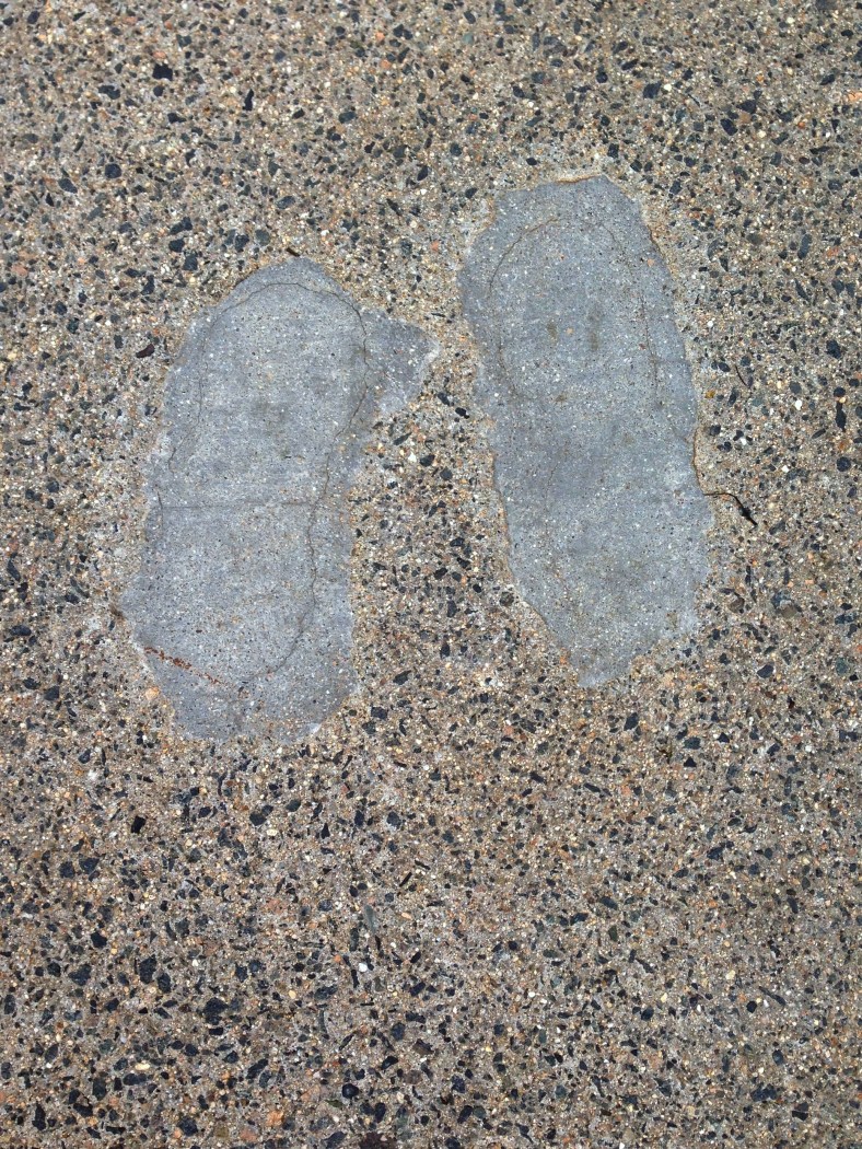 The repaired footprints of someone who decided it was a good idea to stand in wet cement, found along Massachusetts Avenue. May 13, 2014.