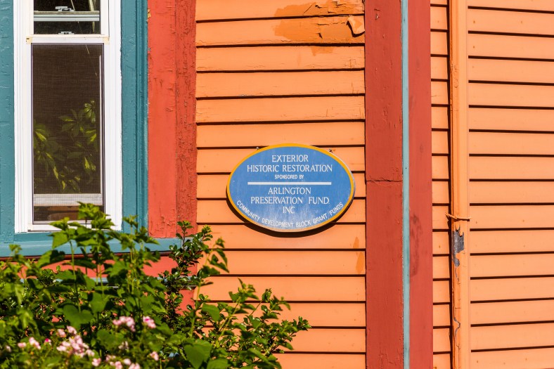 A blue oval plaque on the side of a Teel Street home informing the curious passer by about the restoration work, and who it is sponsored by. June 20, 2014.