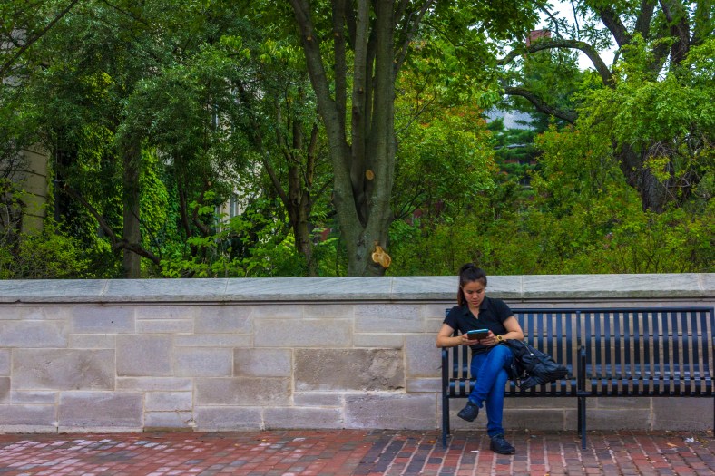 A woman reads on an electronic device while sitting on one of the benches installed outside of Town Hall. August 01, 2014.