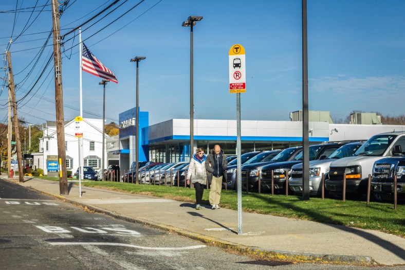 A couple walks by the stop in front of Mirak on Massachusetts Avenue. November 10, 2014.