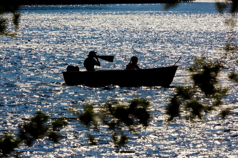 A crew coach shouts instructions through a megaphone during a practice on Spy Pond. September 12, 2013.