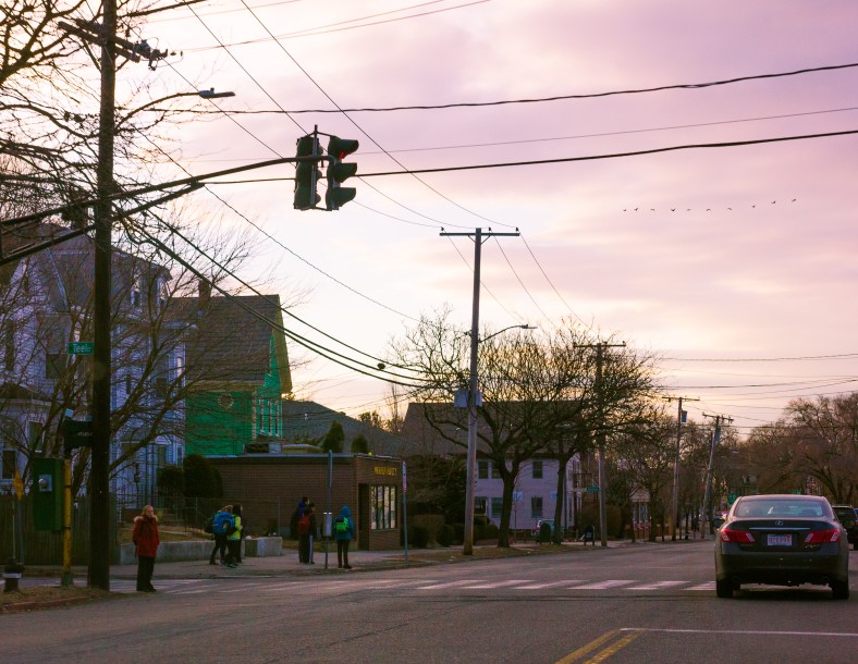 A group of children wait for the 77 bus to take them down Massachusetts Avenue to school. March 21, 2014.