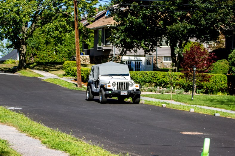 A Jeep, covered from the elements (in this case the sun,) on a newly paved Upland Road. August 05, 2015.