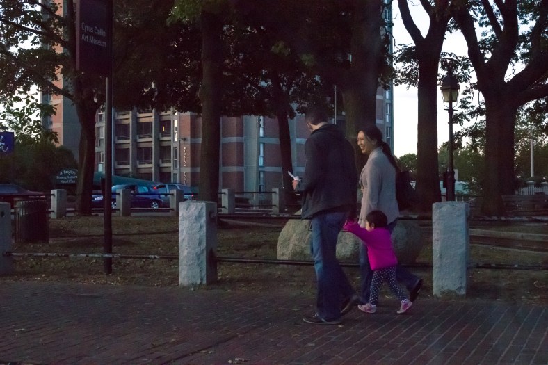 A family enjoying a walk in Arlington Center at twilight. September 26, 2015.