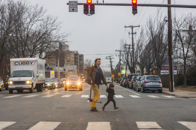 A child and his father cross Massachusetts Avenue near the Stop and Shop supermarket. December 14, 2015.