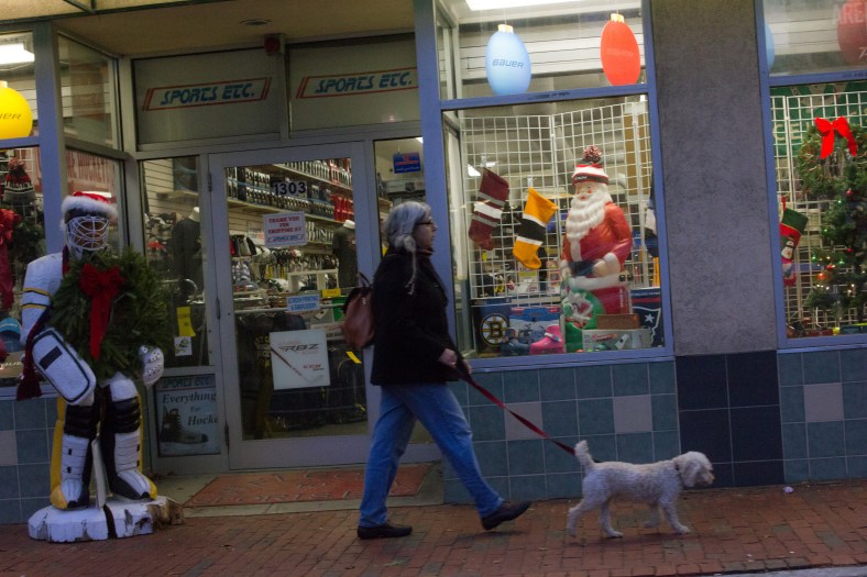 A woman walks her dog past Sports Etc.—decked out for the holidays— in Arlington Heights. December 14, 2015.