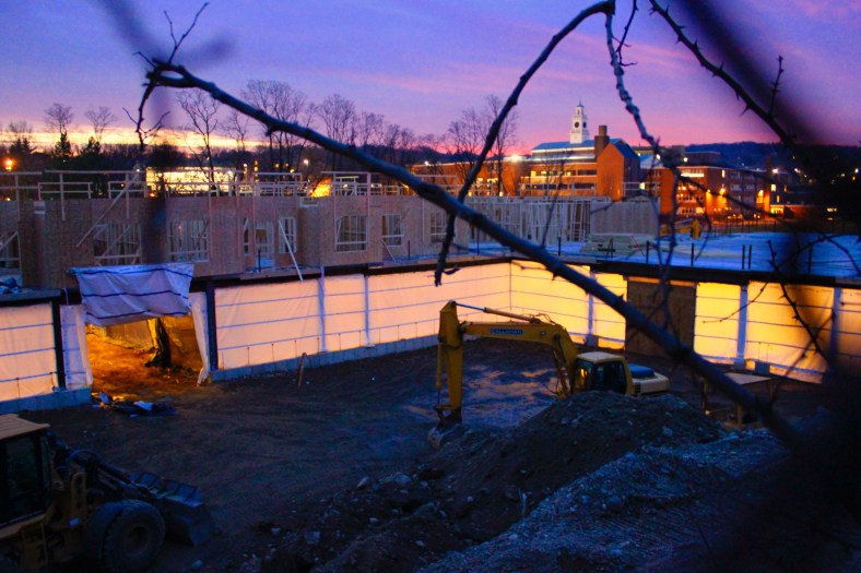 The illuminated construction of the Brigham Square apartments with a backdrop of Arlington High School, and a twilight sky. January 6, 2012.